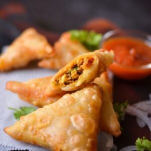 "Chicken Sambousek, crispy fried pastries stuffed with spiced chicken mixture, perfect as appetizers or snacks."