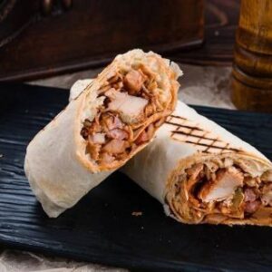 "Chicken Shawarma Sandwich with marinated grilled chicken, garlic sauce and fresh veggies in Lebanese bread"