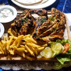"Grilled half chicken, marinated with herbs and spices, charcoal-cooked"